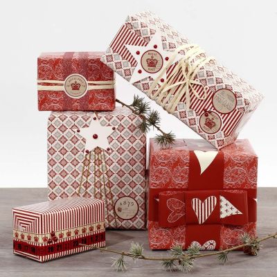 Geschenkverpackungen in Rot-Weiß mit Stickern und Zierbändern